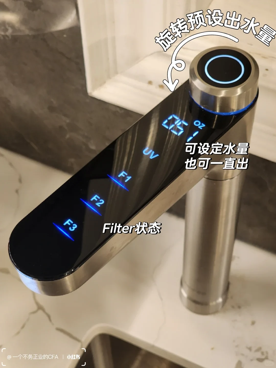 A stainless-steel faucet with a glossy black control panel and a blue-lit circular button is shown over a sink. Its display reads “26 oz,” and blue indicators labeled UV, F1, F2, and F3 are lit. Chinese captions describe presetting or continuously dispensing water and show the filter status.